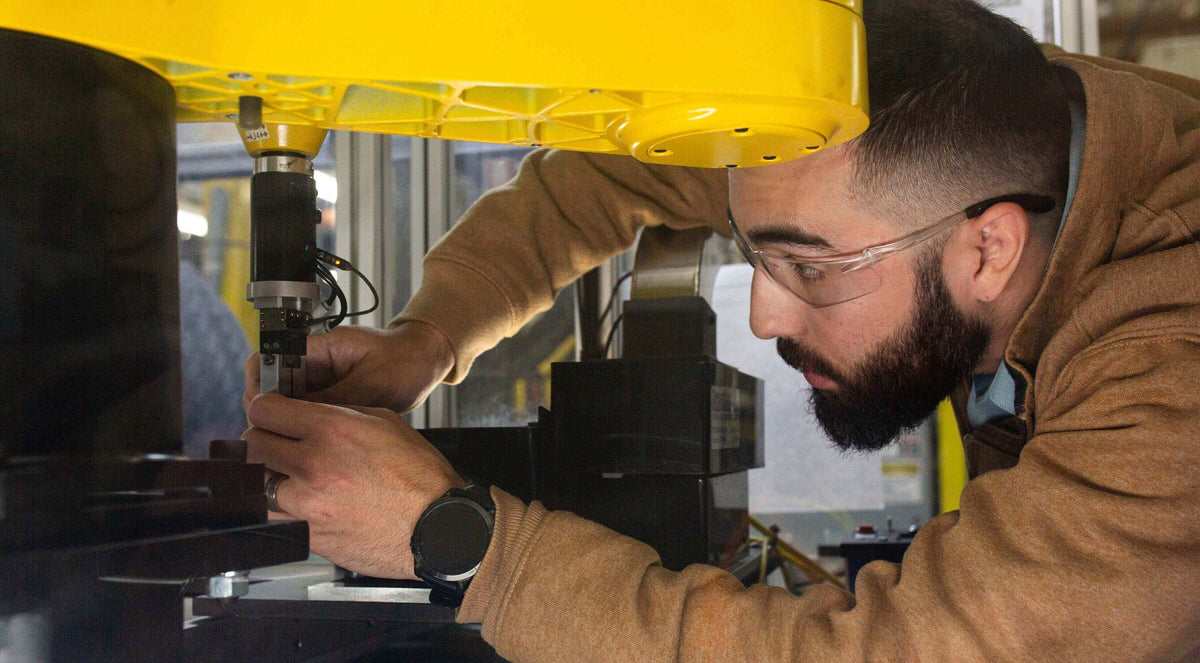 Edward Whidden-Rivera working with precision machinery in a workshop focused on engineering.