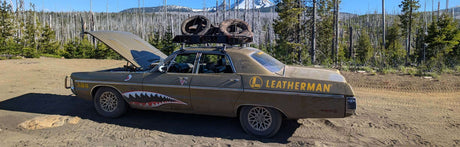 Translation missing: en.Car with Leatherman name and logo on it parked in nature with a raised hood, showcasing adventure and off-road spirit