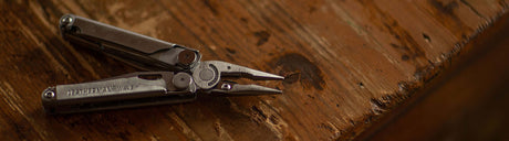 Translation missing: es.Leatherman Wave open in pliers position on wooder table