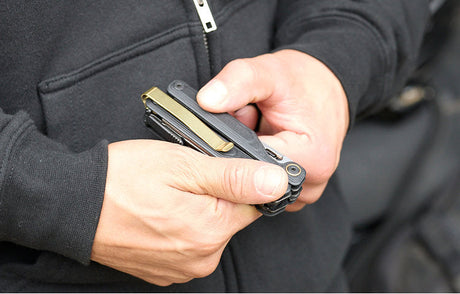 Translation missing: en.Person holding an Obsidian Leatherman Wave® Alpha multi-tool, showcasing the Brass PVD Quick-Release pocket clip