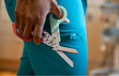 Translation missing: en.Medical person holding a Raptor® Rescue in South Beach color with shears open, showcasing precision tools for cutting
