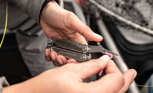 Translation missing: en.Man using scissors on Leatherman Curl to cut string