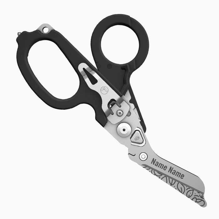 Translation missing: es.A black-handled Leatherman Raptor Rescue tool with floral patterns engraved on the blade. The scissor blade includes the engraved placeholder “Name Name.”