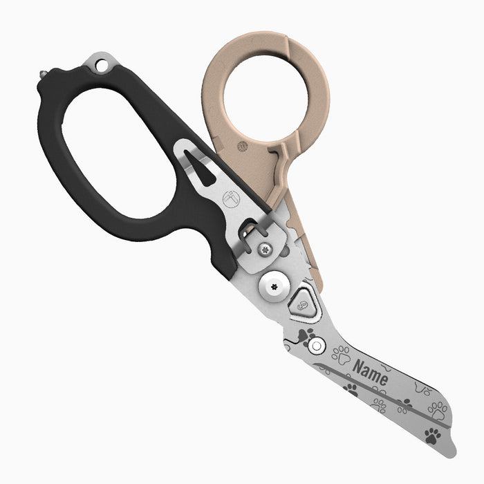 Translation missing: es.A two-tone tan-and-black-handled Leatherman Raptor Rescue tool with pawprints laser printed on the blade, which is personalized with the placeholder “Name.”