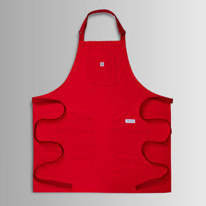 Translation missing: es.Red apron with neck strap, three front pockets, and long waist ties spread out flat