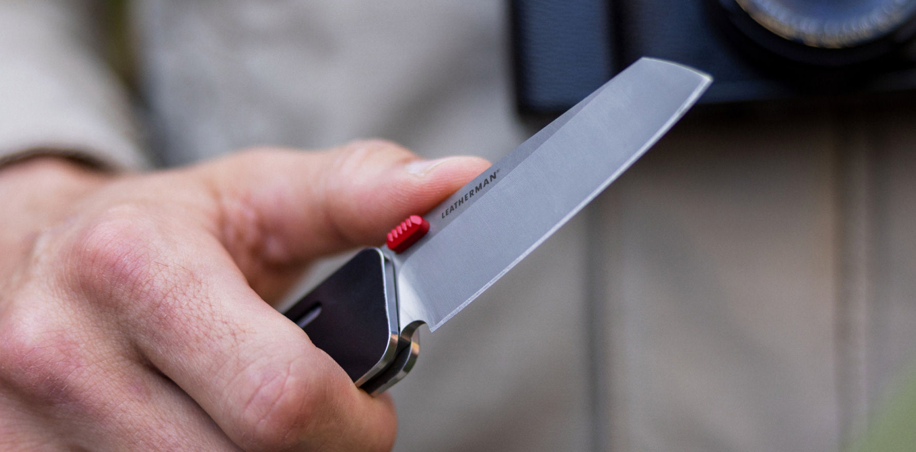 A person is holding Leatherman Glider showing distinctive red button, indicating a specialized function or feature.