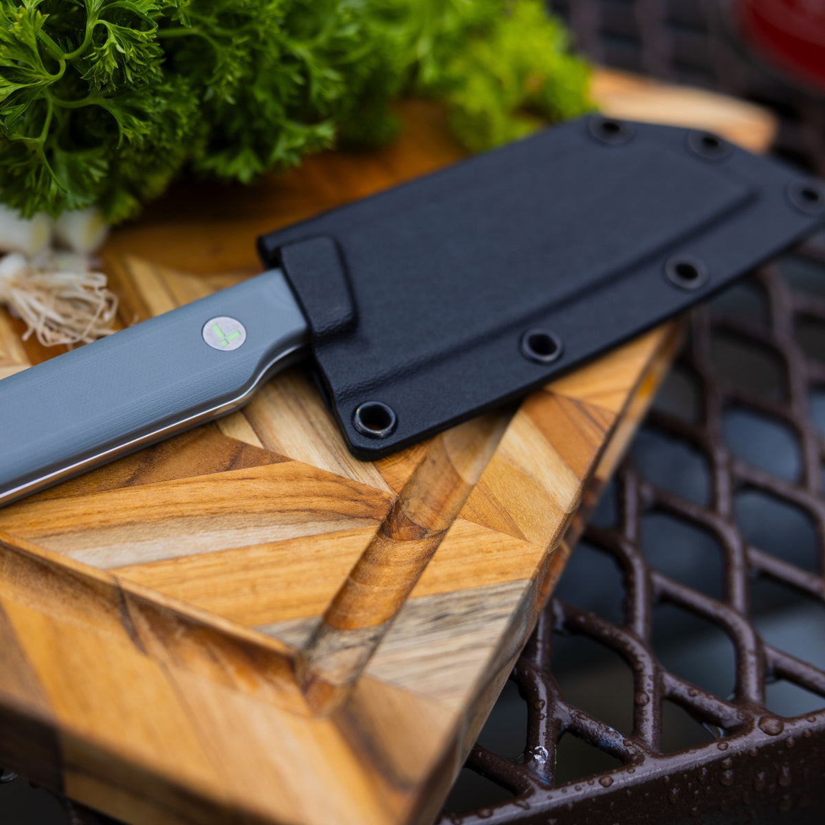 Translation missing: en.Leatherman Rustle in sheath placed on a cutting board alongside a selection of vibrant vegetables, indicating meal preparation