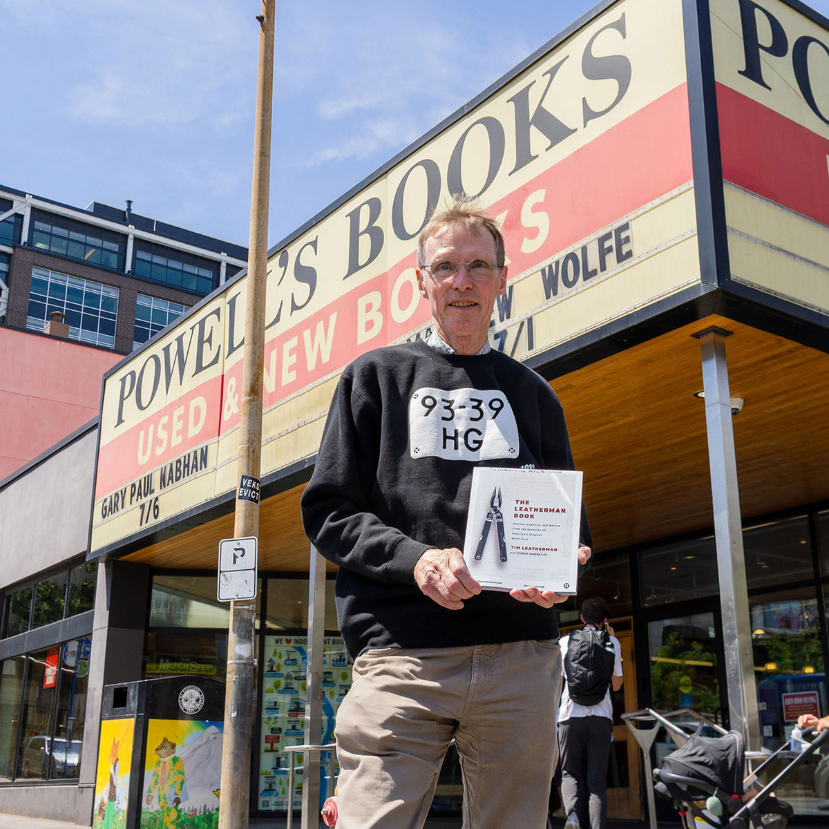 Translation missing: en.Tim Leatherman holding The Leatherman Book outside Powell’s Books in Portland, Oregon