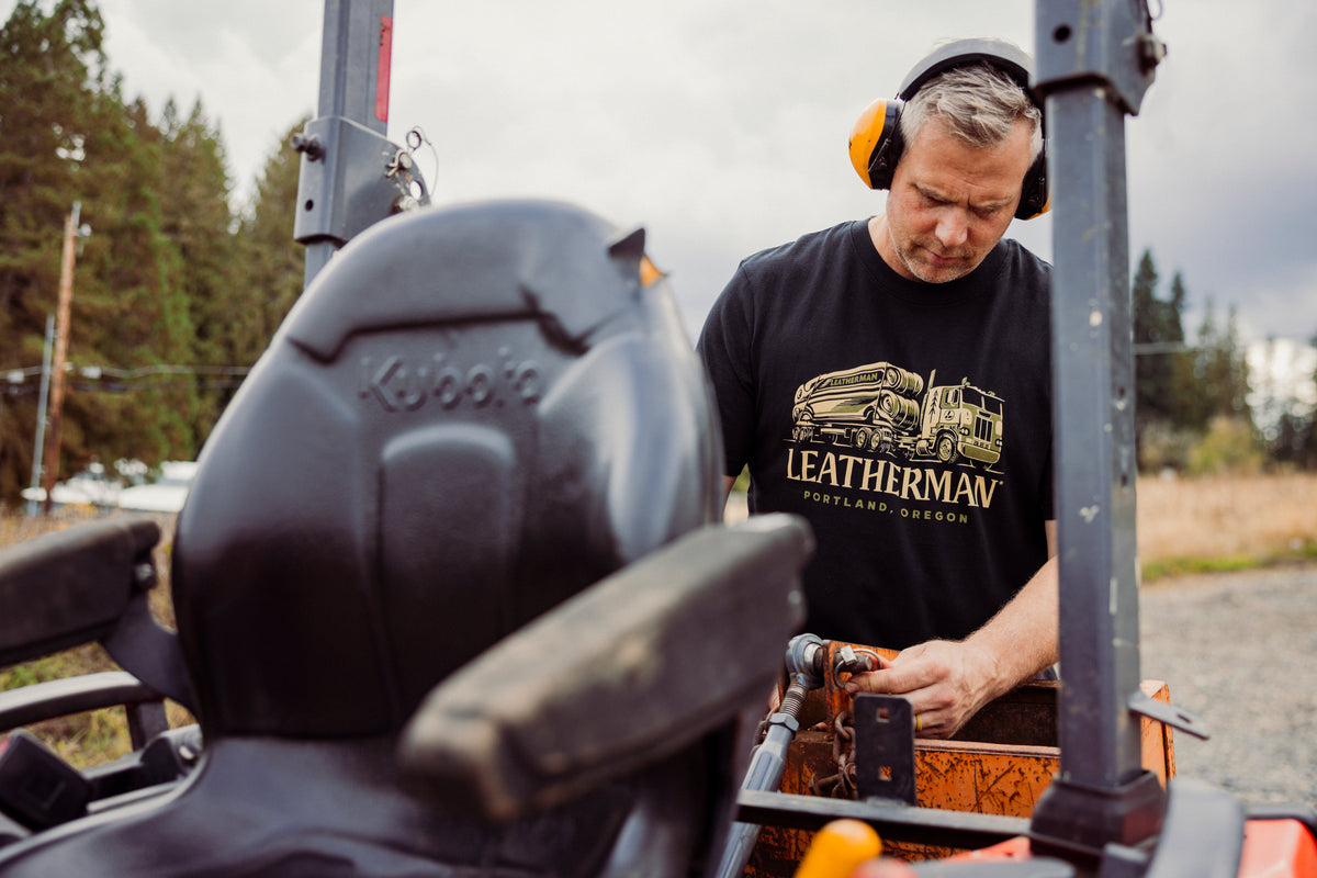 Translation missing: es.A person wearing a black Leatherman Timber Tee working on a tractor outdoors